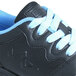 A close up of a black and blue Genuine Grip women's composite toe athletic shoe.