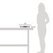 A woman standing next to a table with a Vollrath stainless steel round food pan in it.
