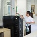 A woman using an Unger indoor window cleaning kit to clean a glass cabinet.