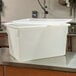 A white plastic Cambro lid on a white plastic container on a metal table.