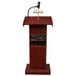 A mahogany podium with a microphone and speaker.