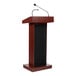 A wooden lectern with a mahogany finish, equipped with a built-in sound system and microphones.