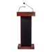 A mahogany finish lectern with built-in sound system and attached microphones.