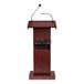A wooden lectern with a mahogany finish, built-in sound system, and two attached microphones.