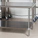 An Advance Tabco stainless steel commercial work table with undershelf on wheels.