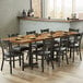 A Lancaster Table & Seating wood butcher block table top with plates and chairs on it.