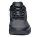 A close up of a black Shoes For Crews men's athletic shoe with laces.