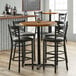 A Lancaster Table & Seating butcher block table with a black pole.