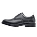 A black Shoes For Crews men's dress shoe with a rubber sole and laces.