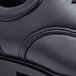 A close up of a black Shoes For Crews Cambridge men's dress shoe with a rubber sole.