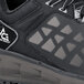 A close up of a black ACE Aster athletic shoe with a logo on the side.