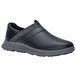 A black Shoes For Crews slip-on shoe with grey soles.