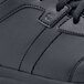 A close up of a black Shoes For Crews Freestyle II athletic shoe with a rubber sole and zipper.