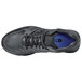 A black Shoes For Crews men's athletic shoe with a blue sole.