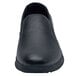 A black Shoes For Crews men's slip-on shoe with a rubber sole.