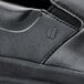 A close up of a black Shoes For Crews Mason casual shoe with a zipper.