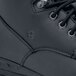 A close up of a black Shoes For Crews work boot with laces.