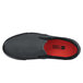 A black Shoes For Crews Ollie II unisex slip on shoe with red soles.