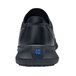 A black Shoes For Crews Karina women's athletic shoe with a blue square logo on the back.