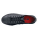 A pair of black Shoes For Crews Delray women's non-slip casual shoes with a red sole on a table.