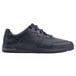 A black Shoes For Crews men's athletic shoe with laces.