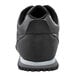 The bottom of a black Shoes For Crews Avery athletic shoe with a white sole.