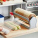 A roll of Western Plastics produce wrapping film on a table being used to wrap food.