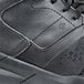 The back of a black Shoes For Crews Hart athletic shoe on a table.