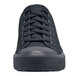 A close up of a black Shoes For Crews Delray casual shoe with laces on the table.