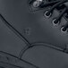 A close up of a black Shoes For Crews work boot with laces.