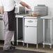 A man cooking food in a Main Street Equipment natural gas floor fryer.