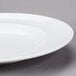 An Arcoroc white porcelain dinner plate with a rim.