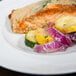 An Arcoroc Vintage dinner plate topped with salmon and vegetables on a table.