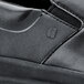 A close up of a black Shoes For Crews Mason casual shoe with a zipper.