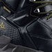 A close up of a black ACE Redrock work boot with a yellow logo.