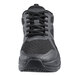 A close up of a black Shoes For Crews athletic shoe with laces.