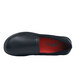 A black Shoes For Crews Quincy women's slip-resistant shoe with a red sole.