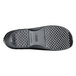 A close-up of a black Shoes For Crews Juno women's shoe with a patterned black sole.