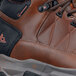 A brown and black leather ACE Highline work boot with a peach logo on the side.