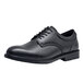 A black Shoes For Crews Cambridge men's dress shoe with laces.