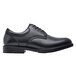 A black Shoes For Crews Cambridge men's dress shoe with a rubber sole.
