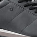 A close up of a black Shoes For Crews Avery athletic shoe with a white sole.