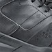 The back of a black Shoes For Crews Hart men's athletic shoe on a table.