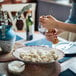 A person grinding food from a GET French Mill melamine bowl.