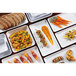 A group of rectangular white melamine bowls filled with food including pasta, basil, and bread.