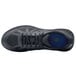 A black Shoes For Crews men's athletic shoe with a blue sole.