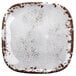 A white square melamine plate with brown speckles.