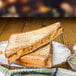 A grilled sandwich with cheese and vegetables on a GET French Mill melamine plate.