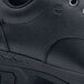 A close up of a black leather Shoes For Crews work boot with a rubber sole.