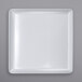 A white square plate on a white surface.